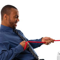 man having tug-o-war with computer