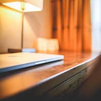 photo of hotel room desk with mac laptop on it
