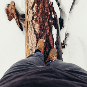 photo of man walking over fallen log in winter scene in HRExaminer.com article, recognize the middle by John Sumser